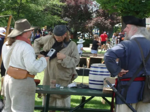 a group of people in historic dress in a green park
